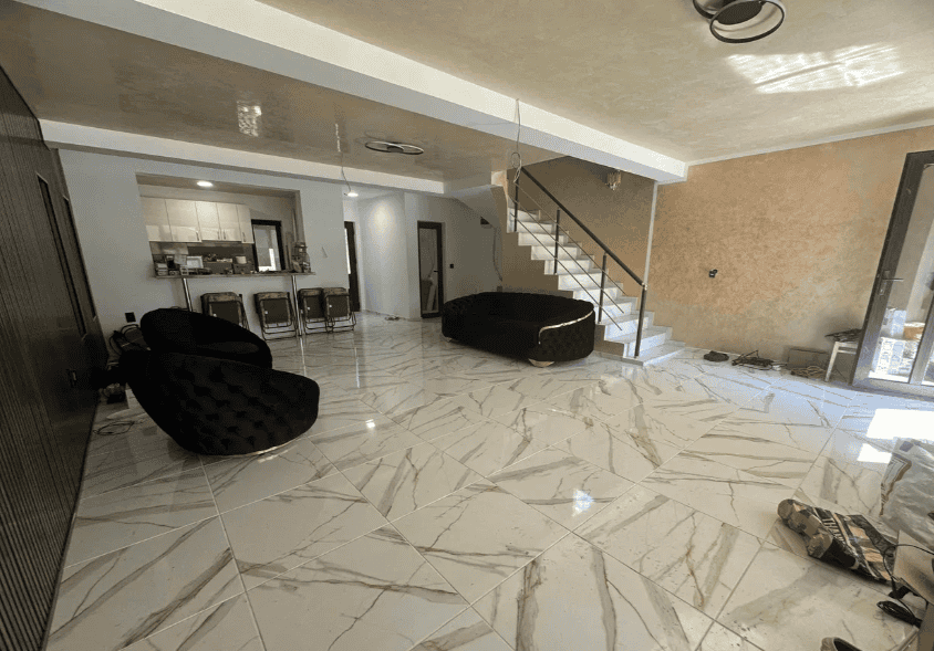 Interior de casă modernă cu mobilier confortabil și podea din marmură lucioasă.