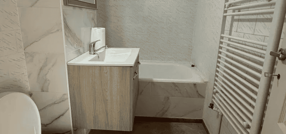 Baie modernă cu mobilier de mobilier din lemn și finisaje din marmură, ideală pentru confort și funcționalitate.