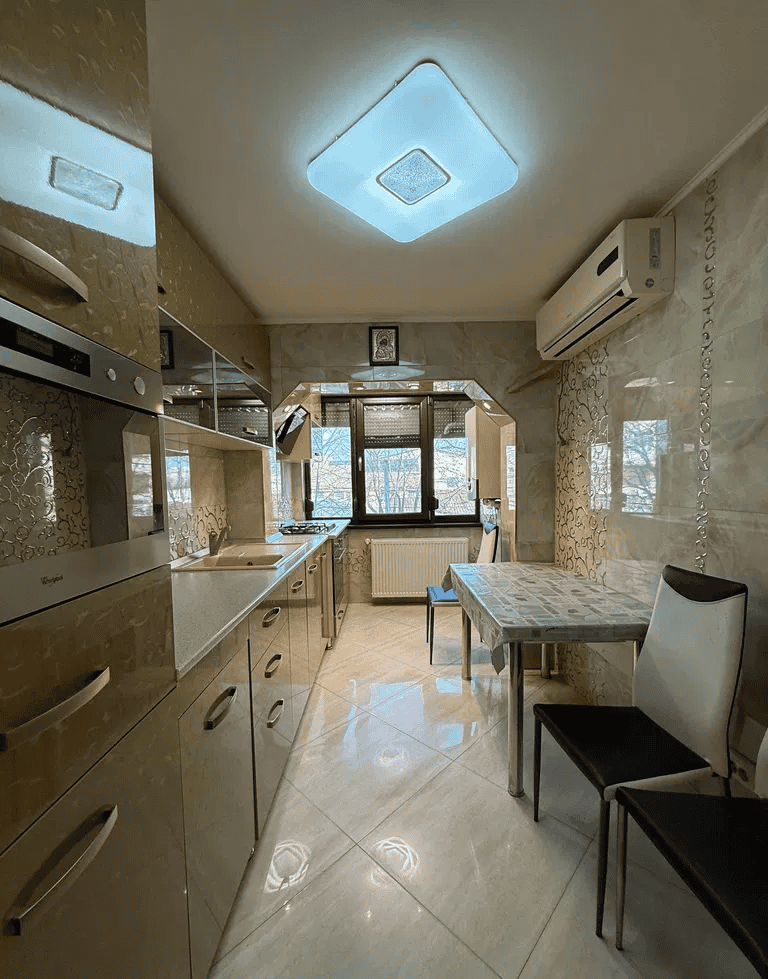 Bucătărie modernă cu mobilier elegant și electrocasnice în apartament de închiriat.