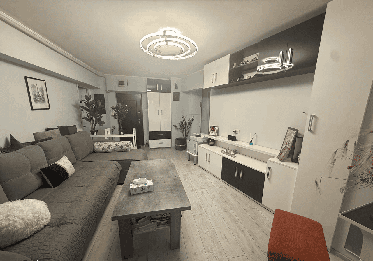 Camera de zi modernă cu mobilier alb și gri, decor elegant și iluminat ambiental pentru confort.