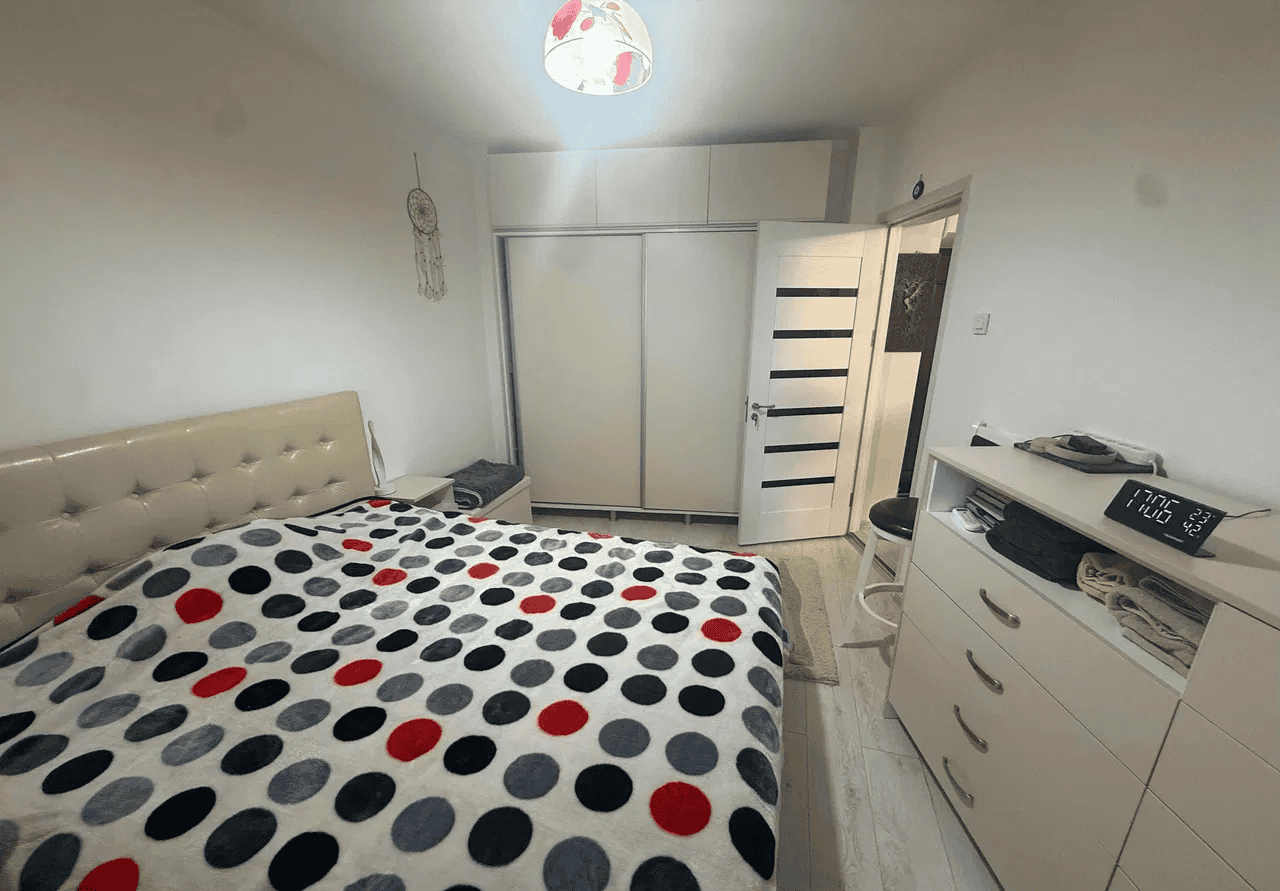 Camera de dormit cu pat confortabil, dulap spațios și decor simplu.