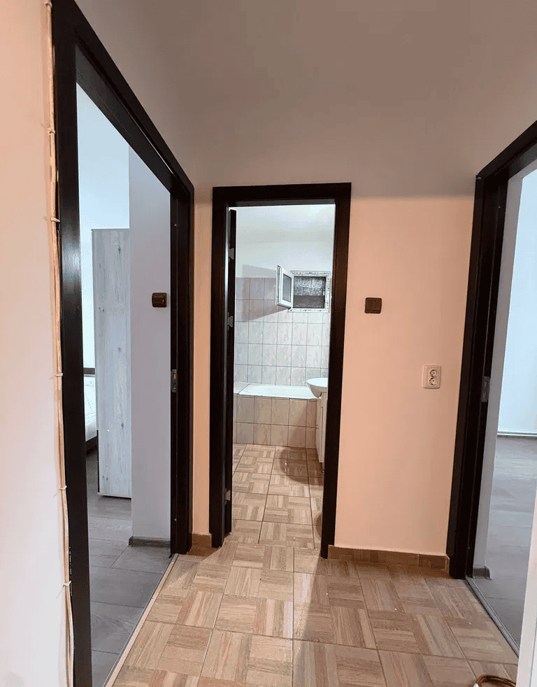 Hol cu uși către băi și camere, finisaje elegante.