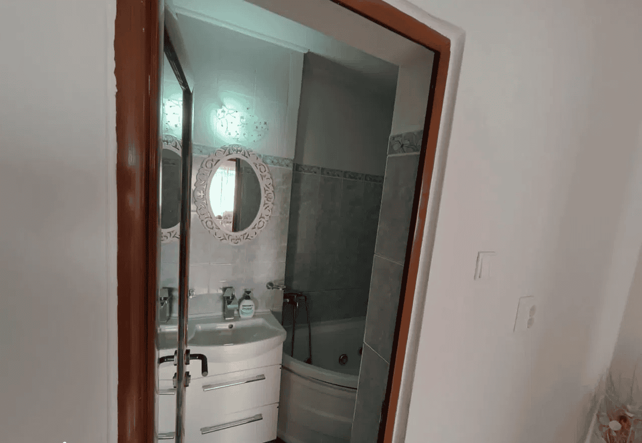 Baie mică cu cadă și chiuvetă, ideală pentru apartamente sau case mici.