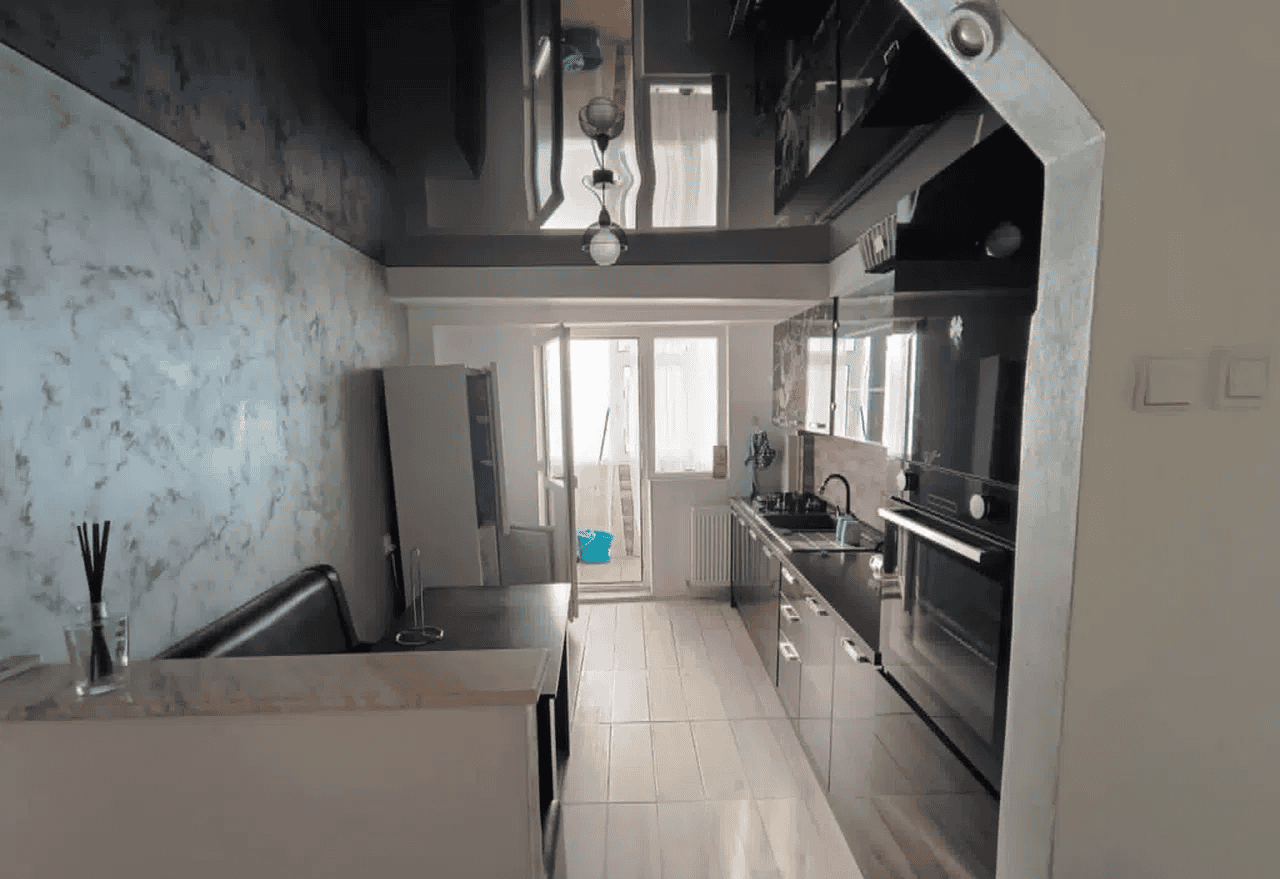 Bucătărie modernă cu electrocasnice și lumină naturală.